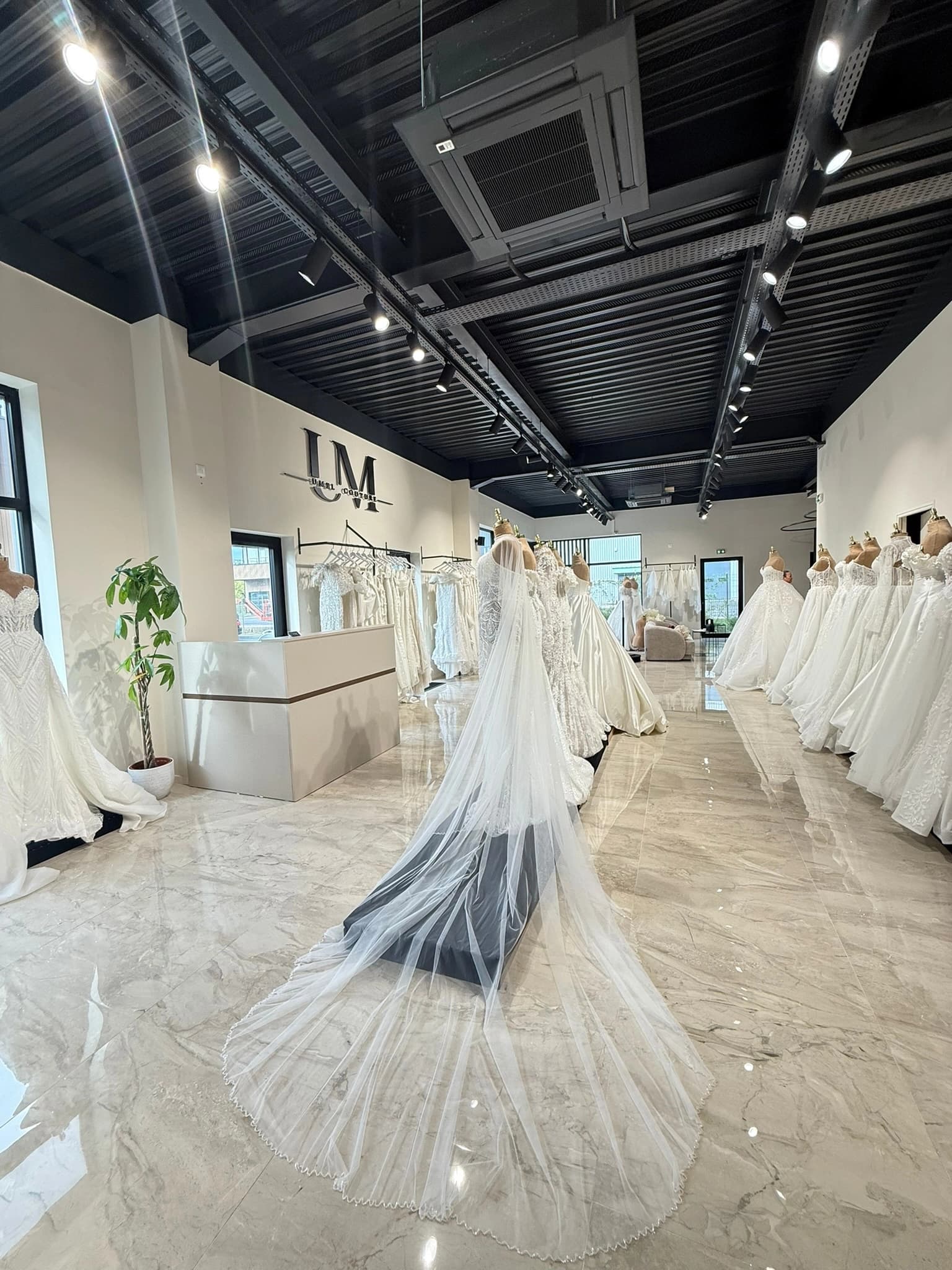 Couturière retouchant une robe de mariée dans l'atelier Umel Couture à Servon (77)